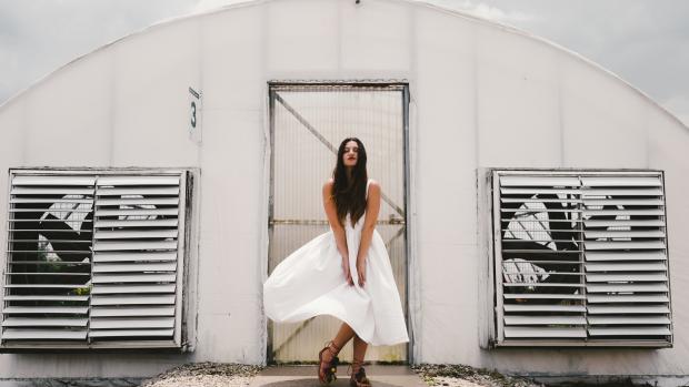 woman standng in front of fan