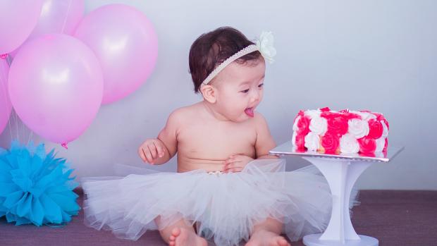 baby looking at a cake